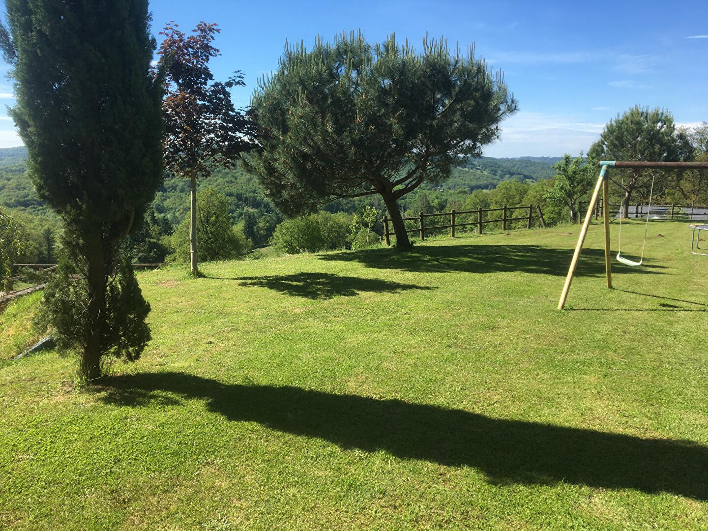 Spacious garden with swing set and trees, located in Corrèze, Nouvelle-Aquitaine, showcasing outdoor potential for the