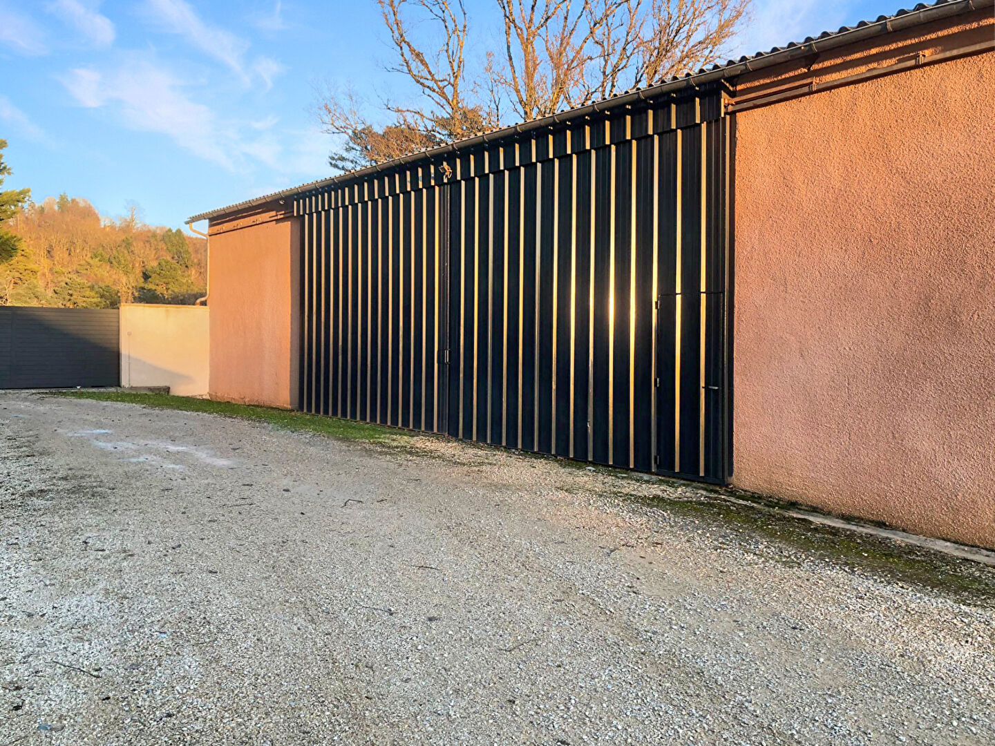 Large property with a modern façade in Corrèze, Nouvelle-Aquitaine, featuring a spacious gravel driveway.
