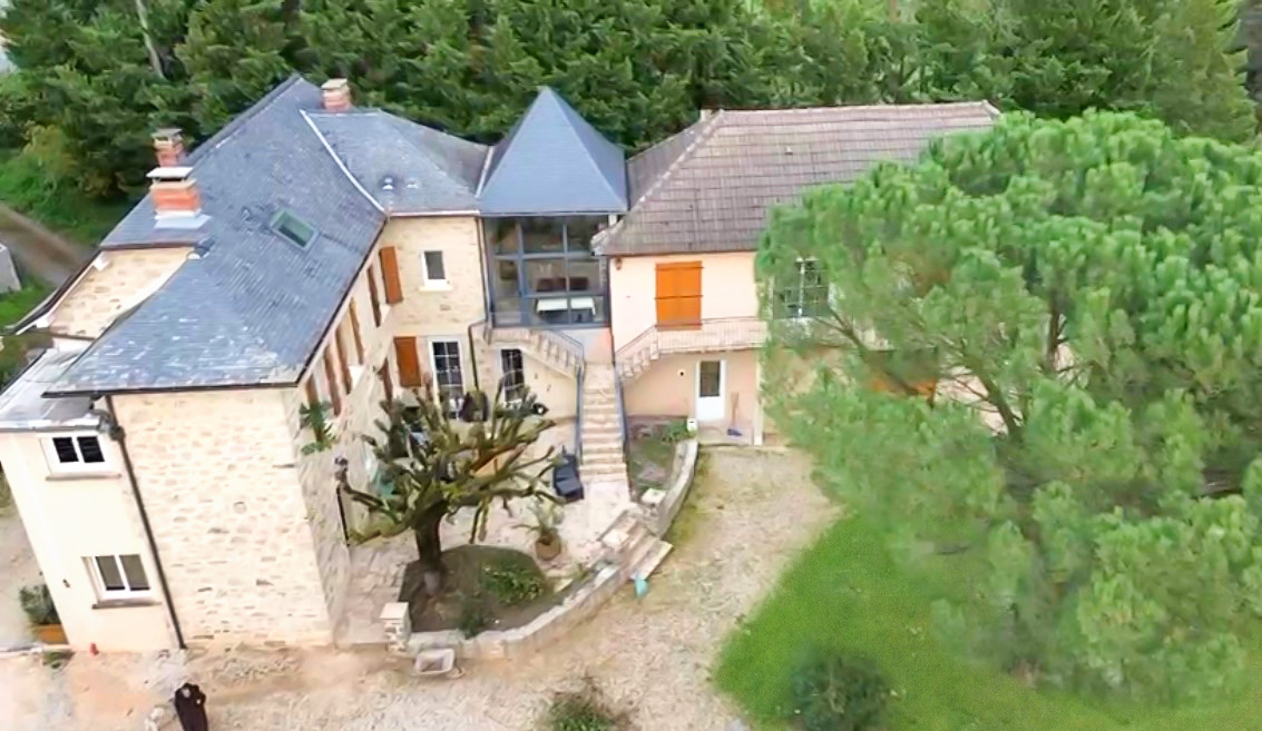 Spacious property in Corrèze, Nouvelle-Aquitaine, featuring a large garden, unique architecture, and multiple outdoor areas.