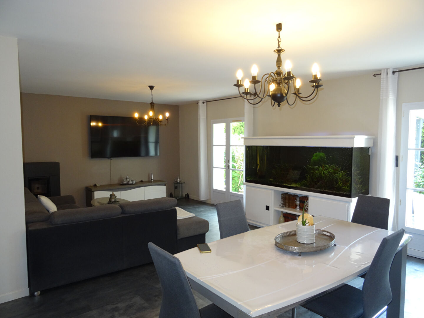 Spacious living area featuring a dining table, lounge space, and aquarium, located in Vendée, Pays-de-la-Loire.