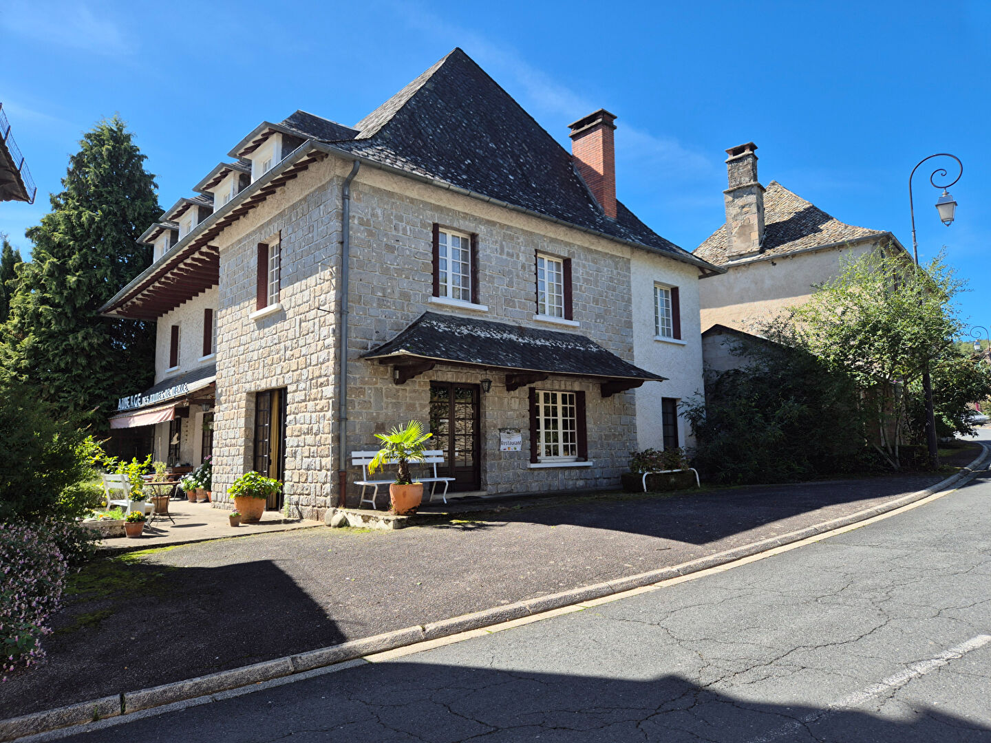Two-bedroom property in Corrèze, Nouvelle-Aquitaine, featuring a stone façade and outdoor seating area.