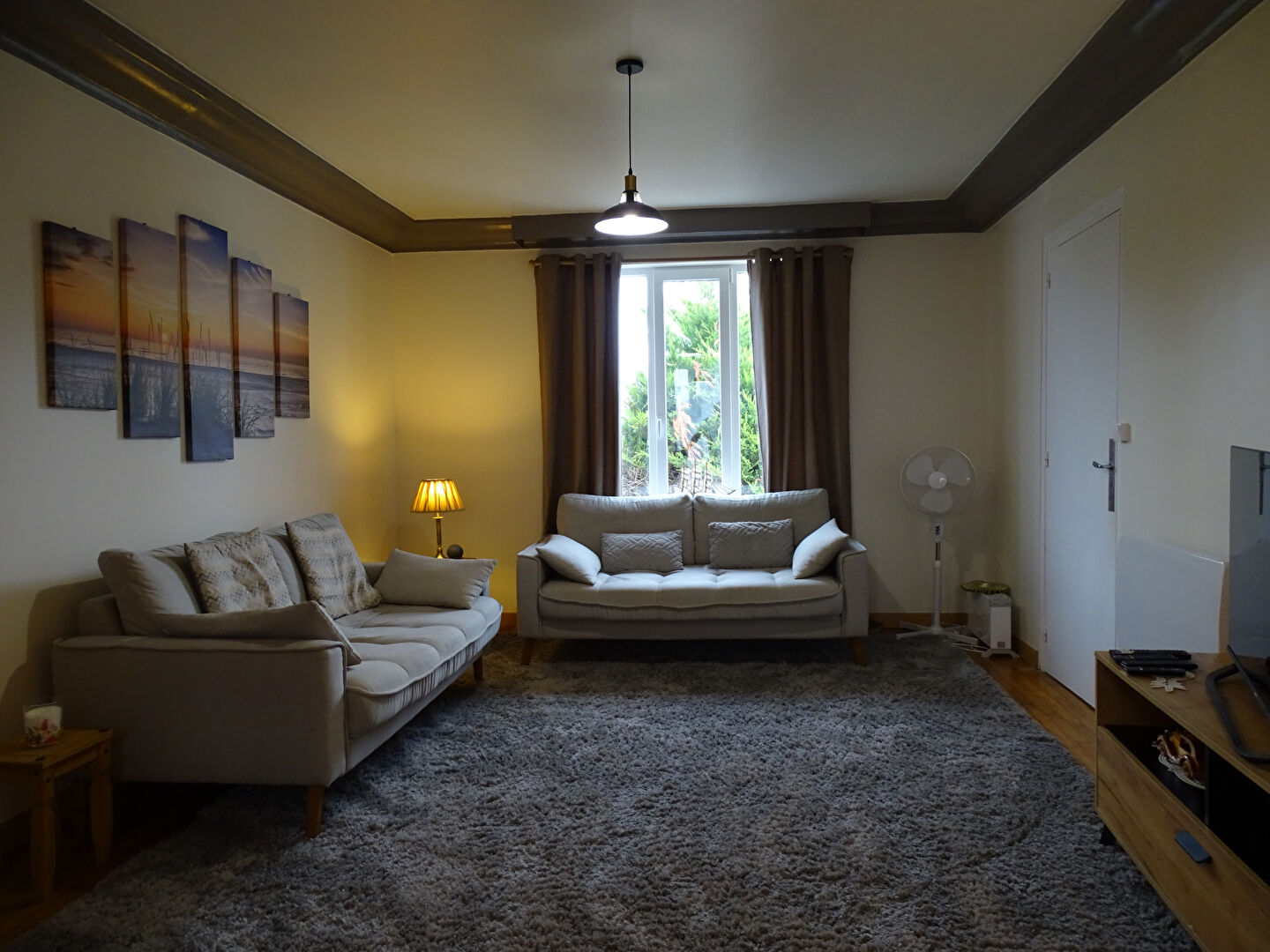 Spacious living room in a property located in Finistère, Brittany, with comfortable sofas and large window.
