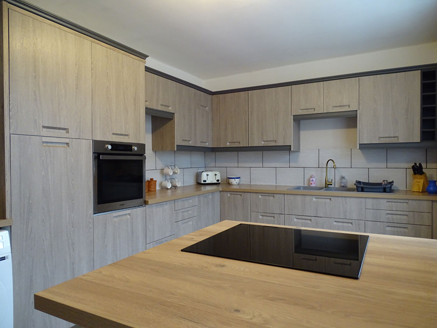 Modern kitchen featuring wooden cabinetry and island in Finistère, Brittany, with ample storage for a 3-bedroom property.