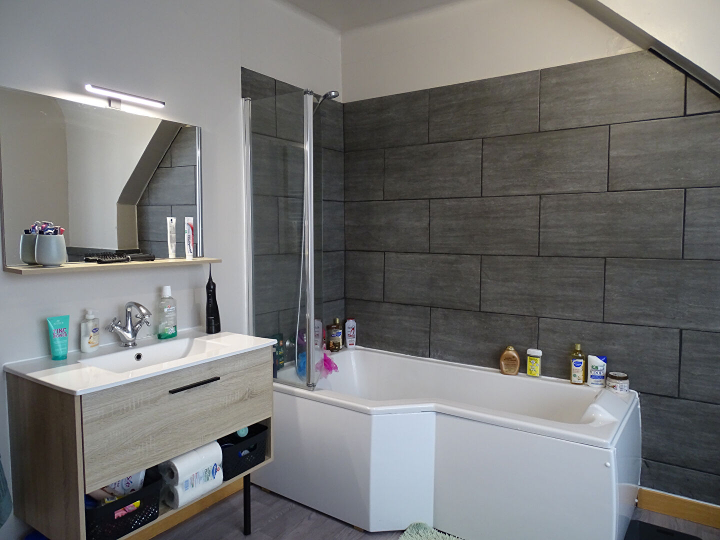 Modern bathroom featuring a bathtub and stylish vanity in Finistère, Brittany.