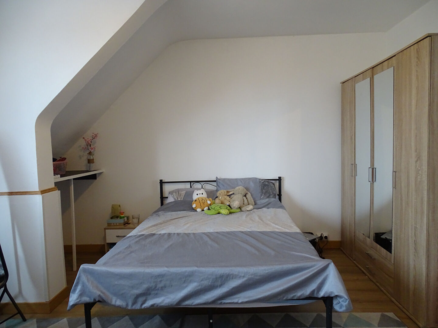 Spacious bedroom with double bed and wardrobe in Finistère, Brittany, featuring neutral decor and natural light.