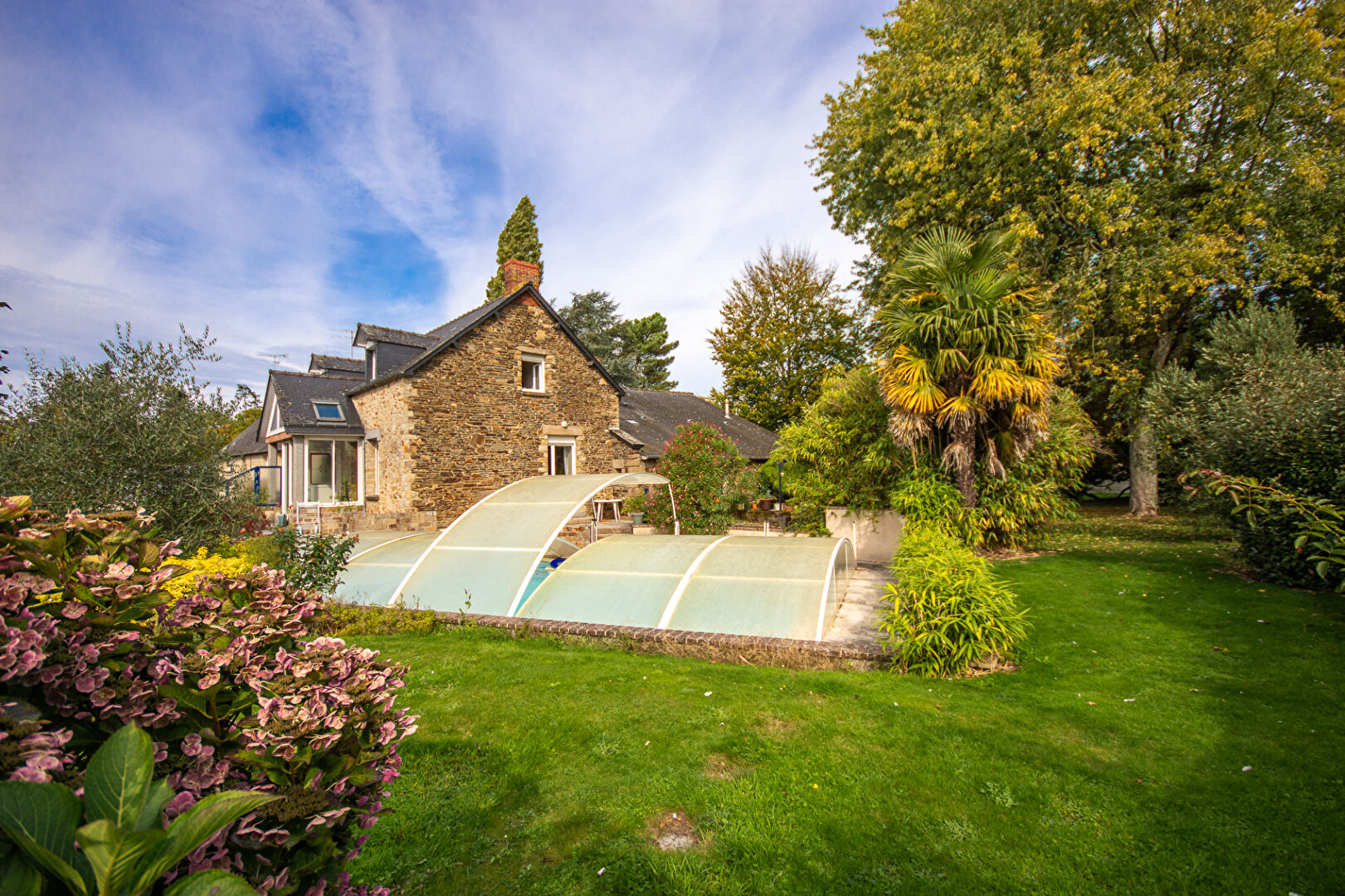 Property with swimming pool in Manche, Normandy, featuring a landscaped garden and charming stone architecture.
