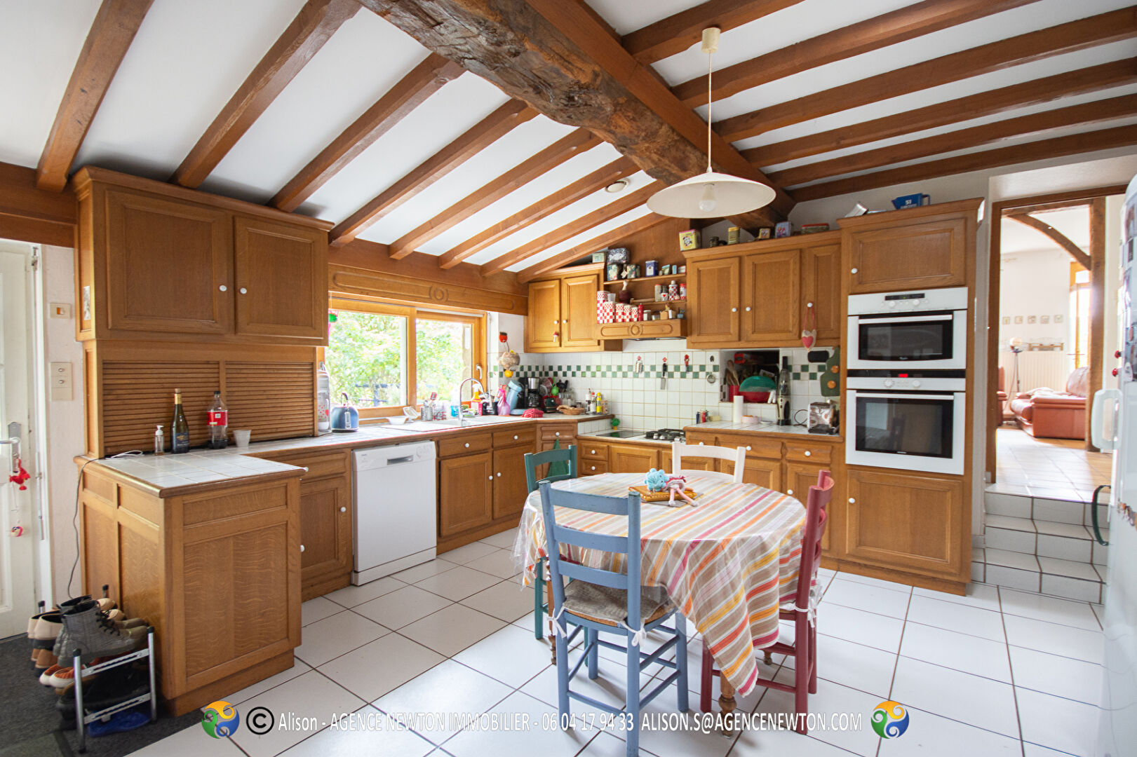 Property in Manche, Normandy, featuring a spacious kitchen with wooden beams and a swimming pool.