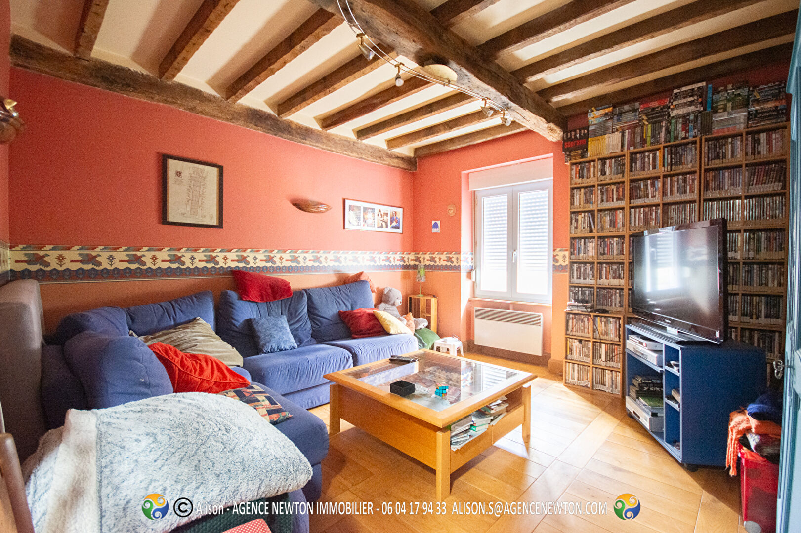 Four-bedroom property in Manche, Normandy, featuring a swimming pool and a cosy living area with wooden beams.
