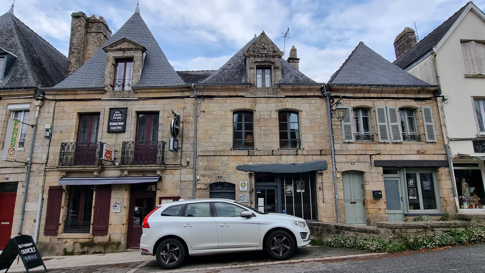 Property in Morbihan, Brittany, featuring stone architecture and multiple storeys, situated in a lively street.