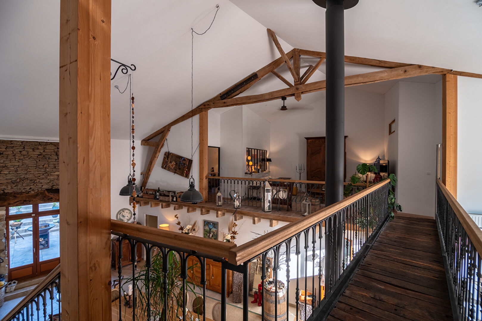 Spacious property in Haute-Vienne with high ceilings, wooden beams, and open balcony overlooking a charming living area.