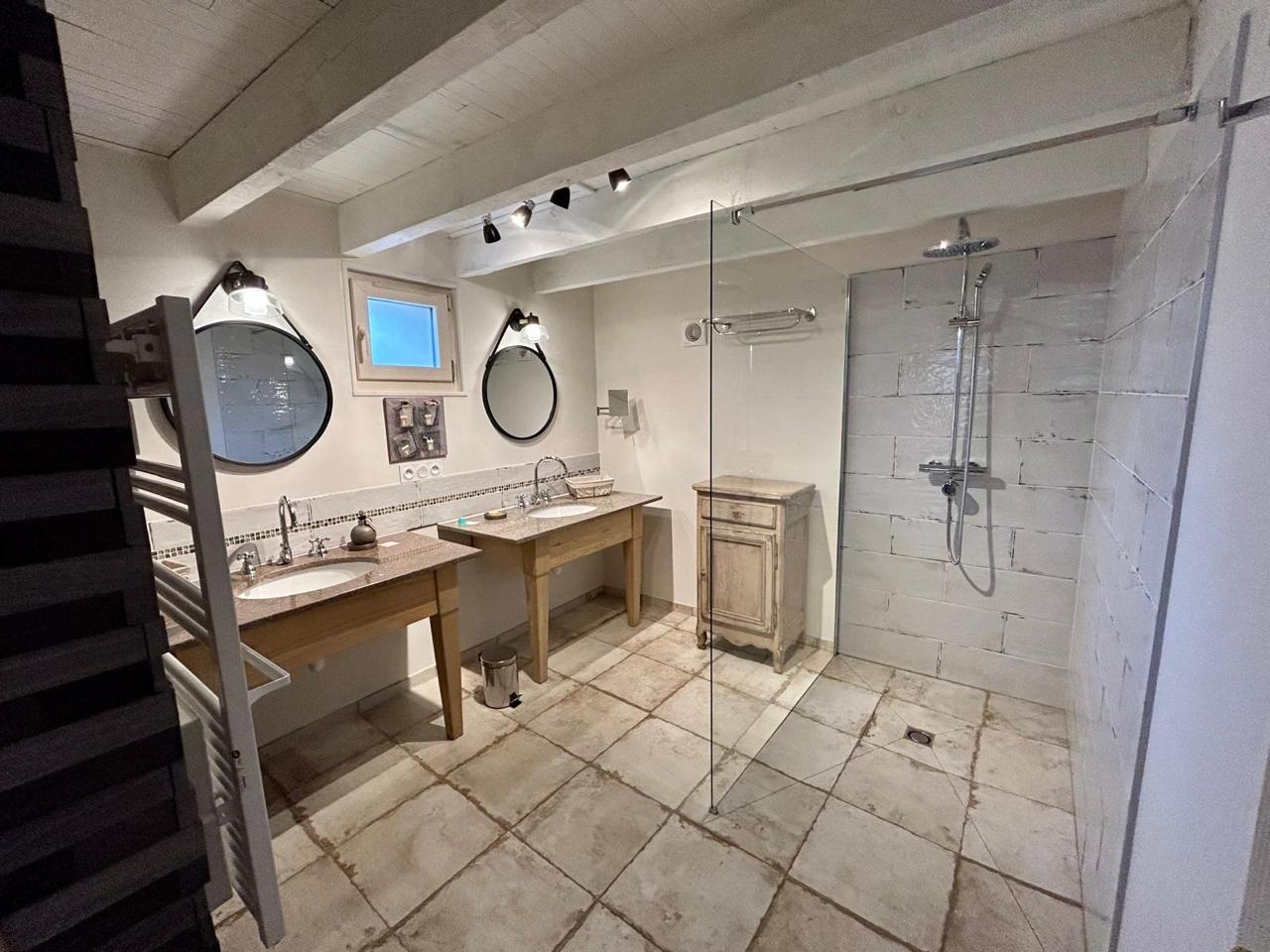 Spacious bathroom featuring two sinks, modern shower, and rustic decor in Haute-Vienne, Nouvelle-Aquitaine.