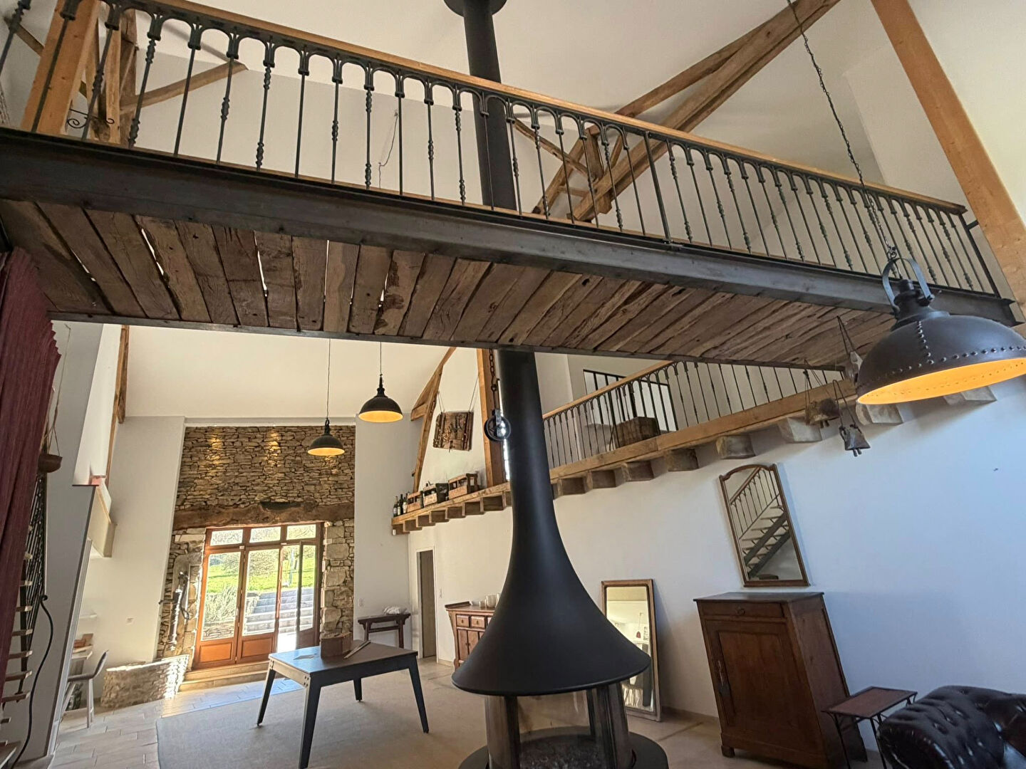 Spacious property in Haute-Vienne, featuring high ceilings, wooden beams, and a striking central fireplace.