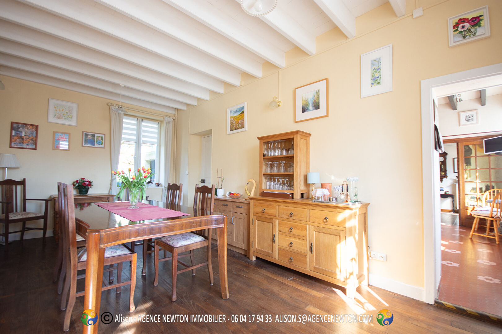 Spacious property in Mayenne featuring a dining area with wooden furniture and natural light from large windows.