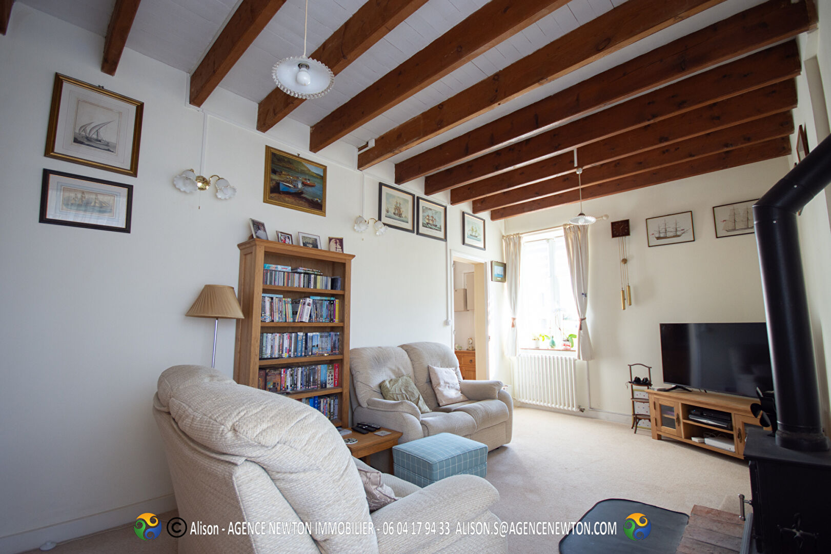 Spacious property in Mayenne, Pays-de-la-Loire, featuring a cosy lounge with wooden beams and ample natural light.