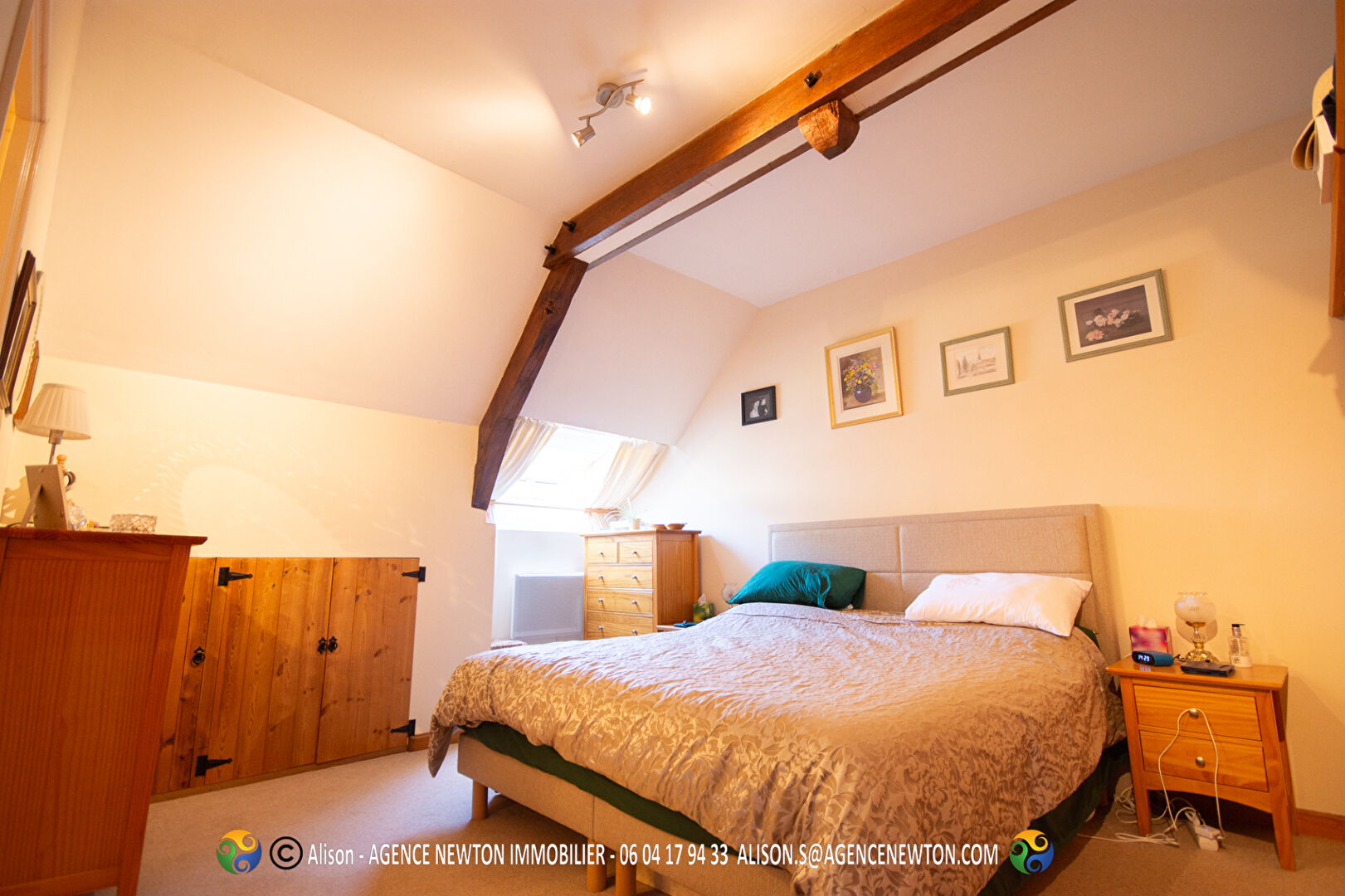 Spacious bedroom with wooden beams in a property located in Mayenne, Pays-de-la-Loire, featuring a double bed and storage.