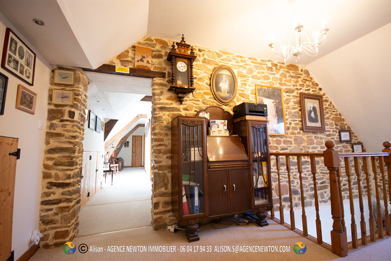 Spacious property in Mayenne featuring exposed stone walls and wooden staircase, ideal for family living.