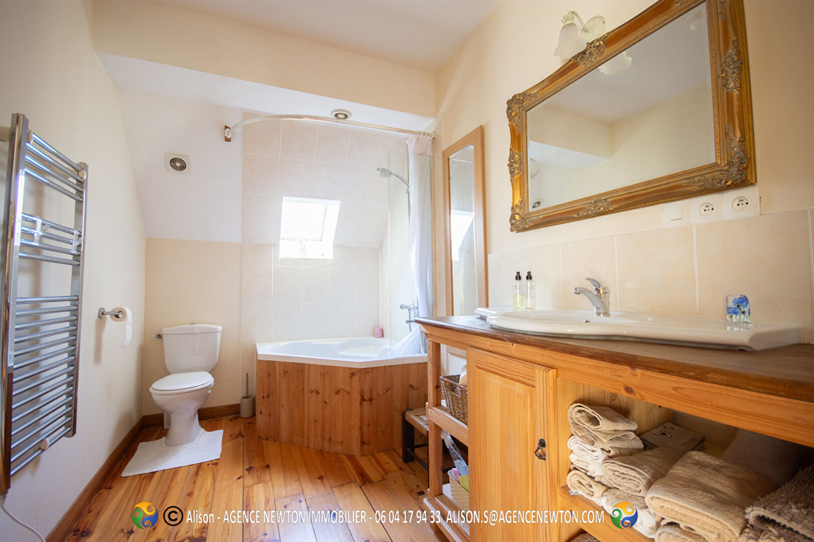 Spacious bathroom featuring a bath and wooden accents in a property located in Mayenne, Pays-de-la-Loire.