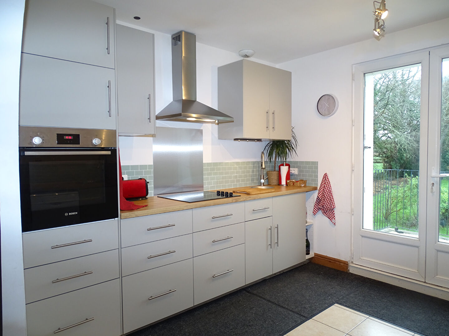 Modern kitchen in a property located in Morbihan, Brittany, featuring sleek cabinets and access to outdoor space.