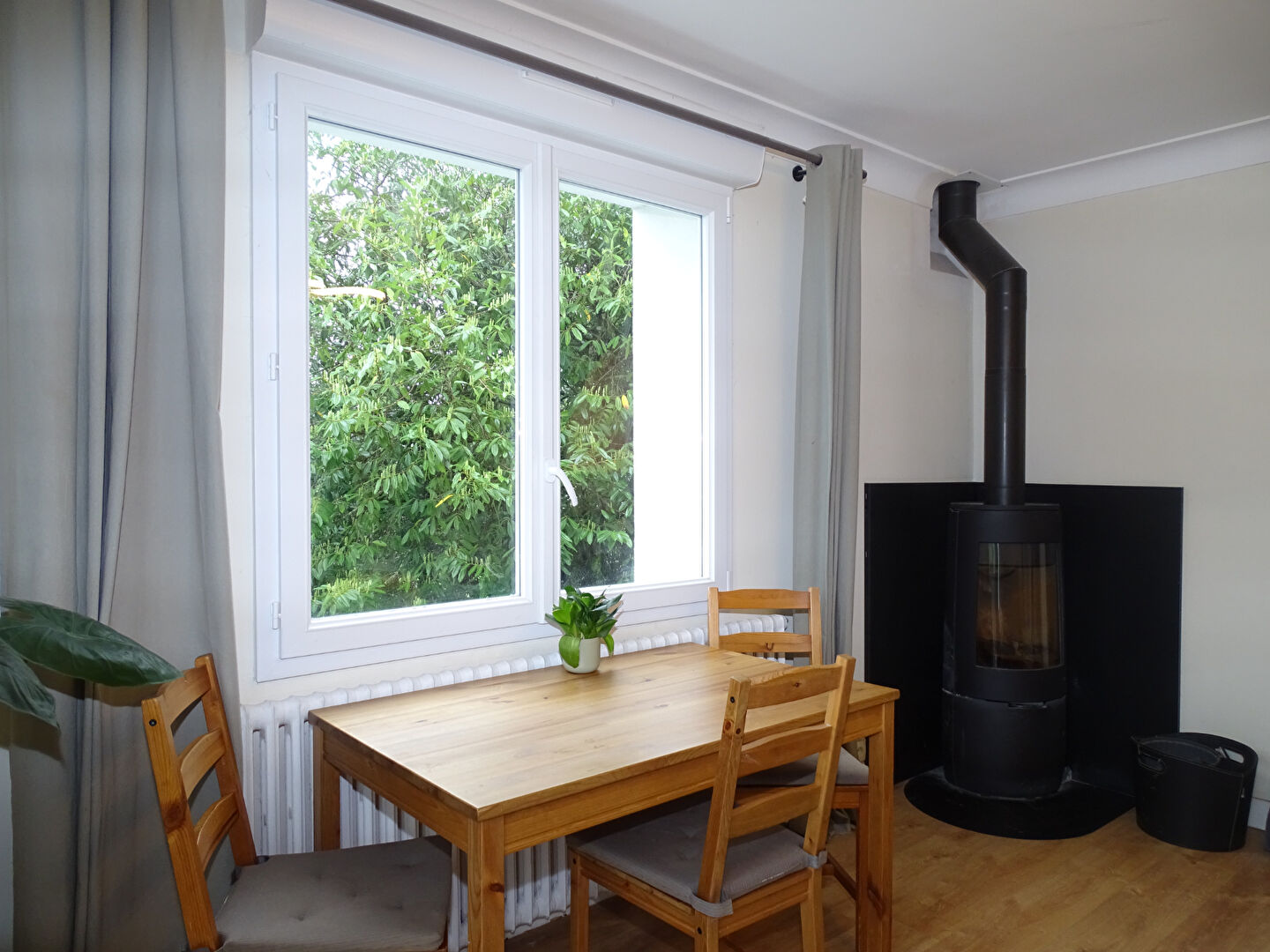 Dining area featuring a wooden table, chairs, and a stove, located in Morbihan, Brittany.