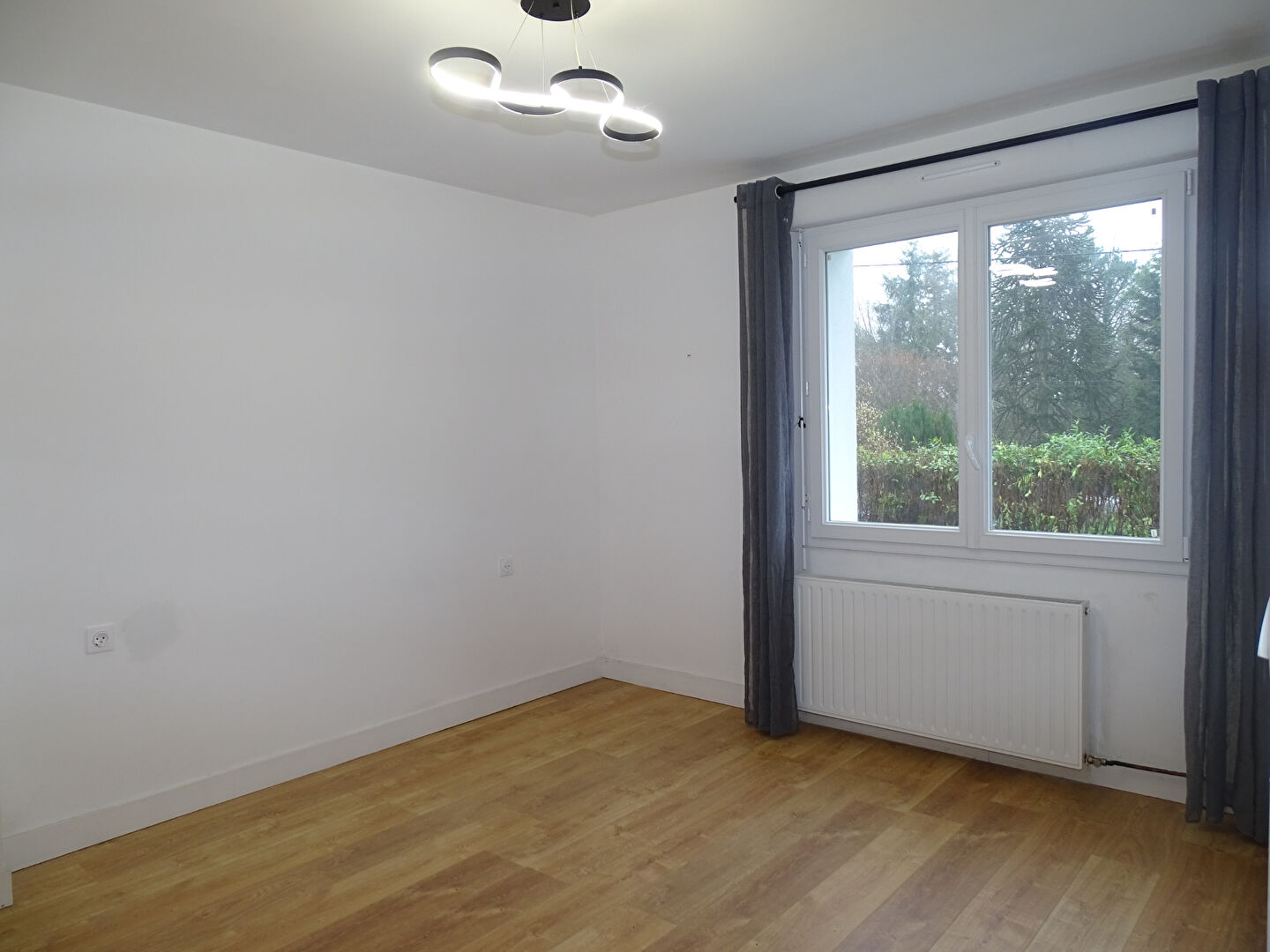 Bright room in property located in Morbihan, Brittany, featuring large window and wooden flooring.