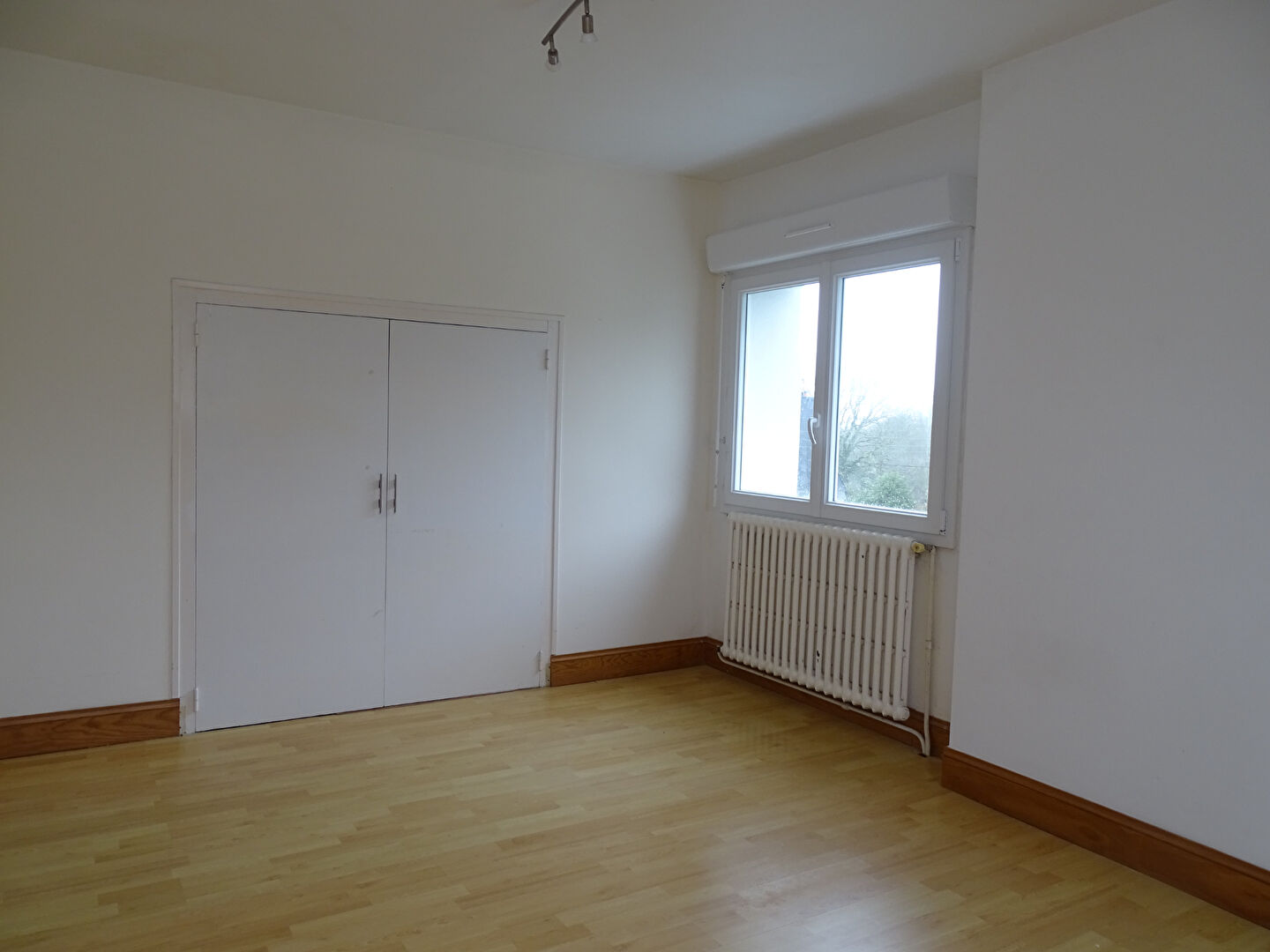 Spacious property in Morbihan, Brittany with wooden flooring and large windows, featuring a built-in wardrobe.