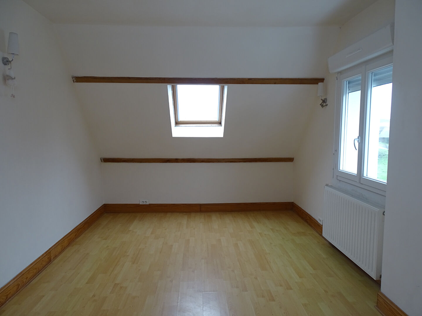 Spacious room with wooden flooring and sloped ceiling, located in Morbihan, Brittany, featuring 4 bedrooms.