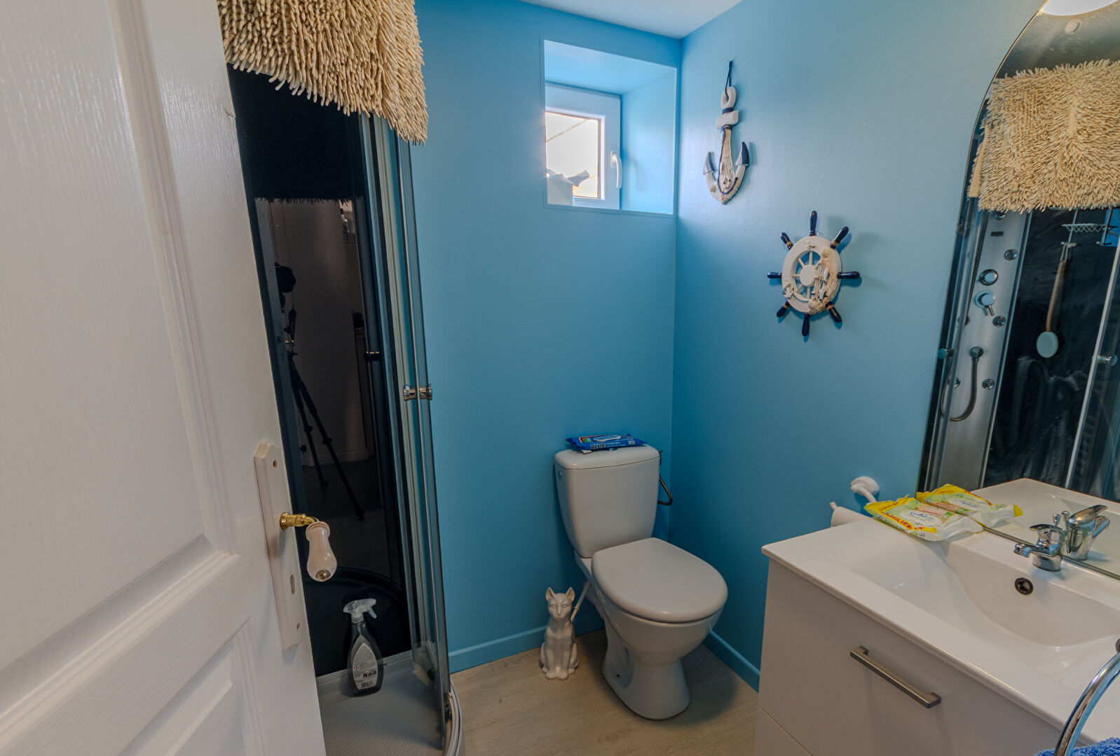 Bright bathroom featuring blue walls, modern fixtures, and nautical decor in Manche, Normandy.