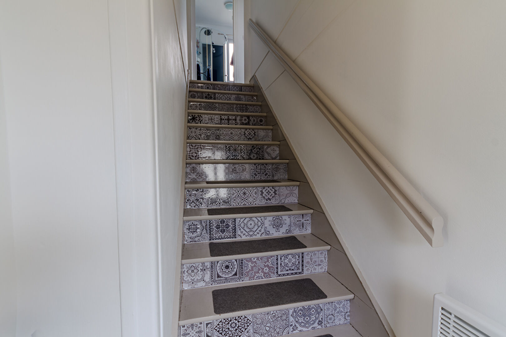 Staircase with patterned tiles leading to upper level in property located in Manche, Normandy, postcode 50150.