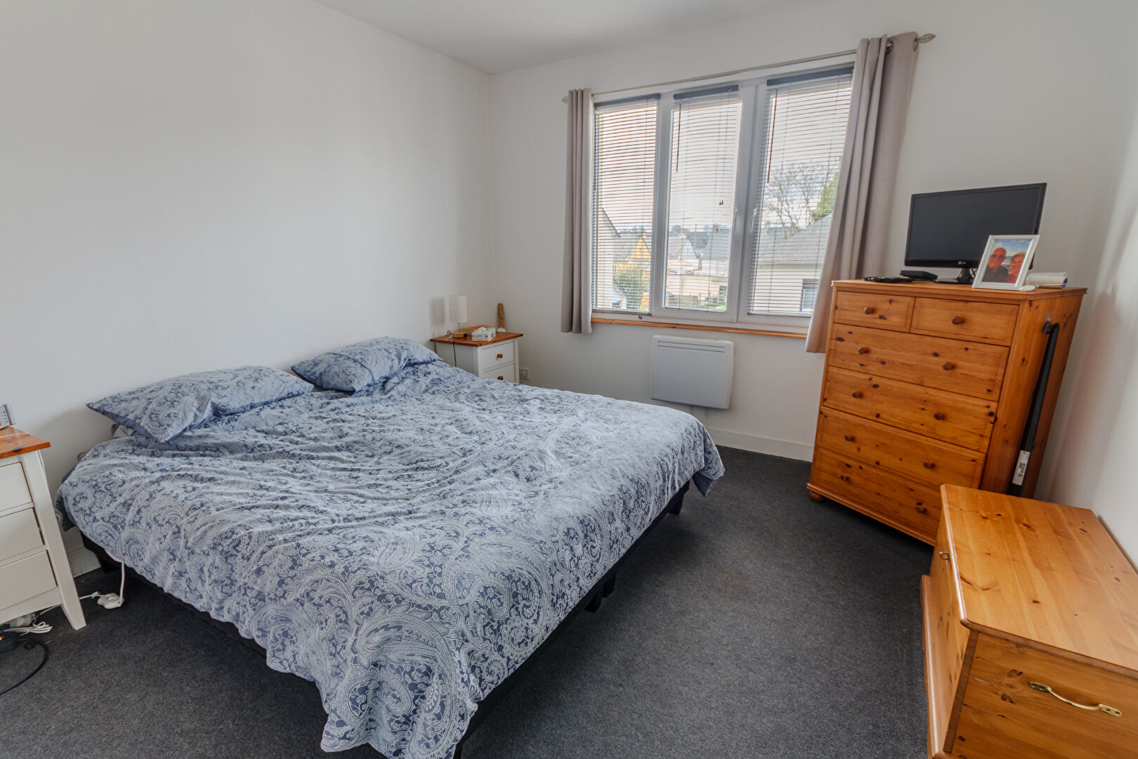 Spacious bedroom with a double bed, wardrobe, and natural light in a property located in Manche, Normandy.