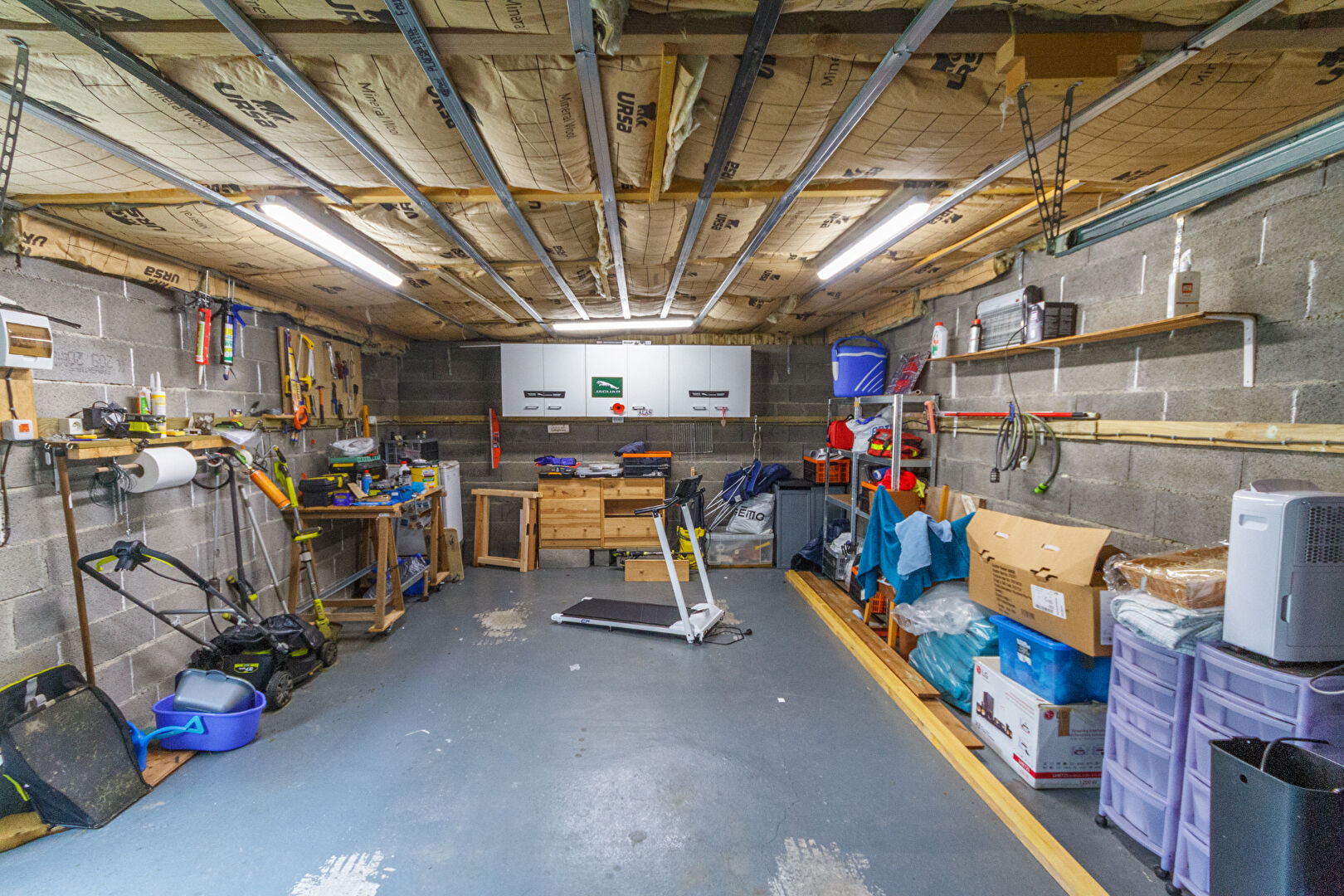 Spacious garage in Manche, Normandy, featuring storage shelves and tools, ideal for a property with renovation potential.