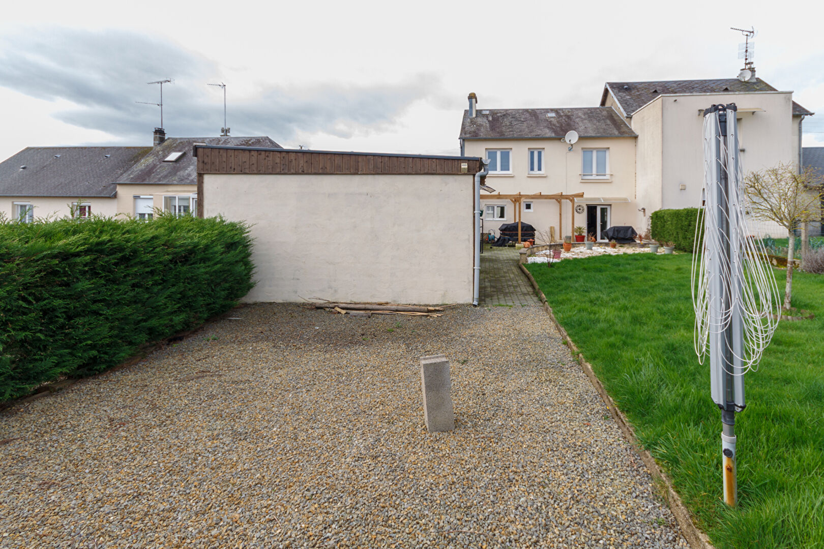 Three-bedroom property with garden space in Manche, Normandy, showcasing outdoor area and adjoining structures.