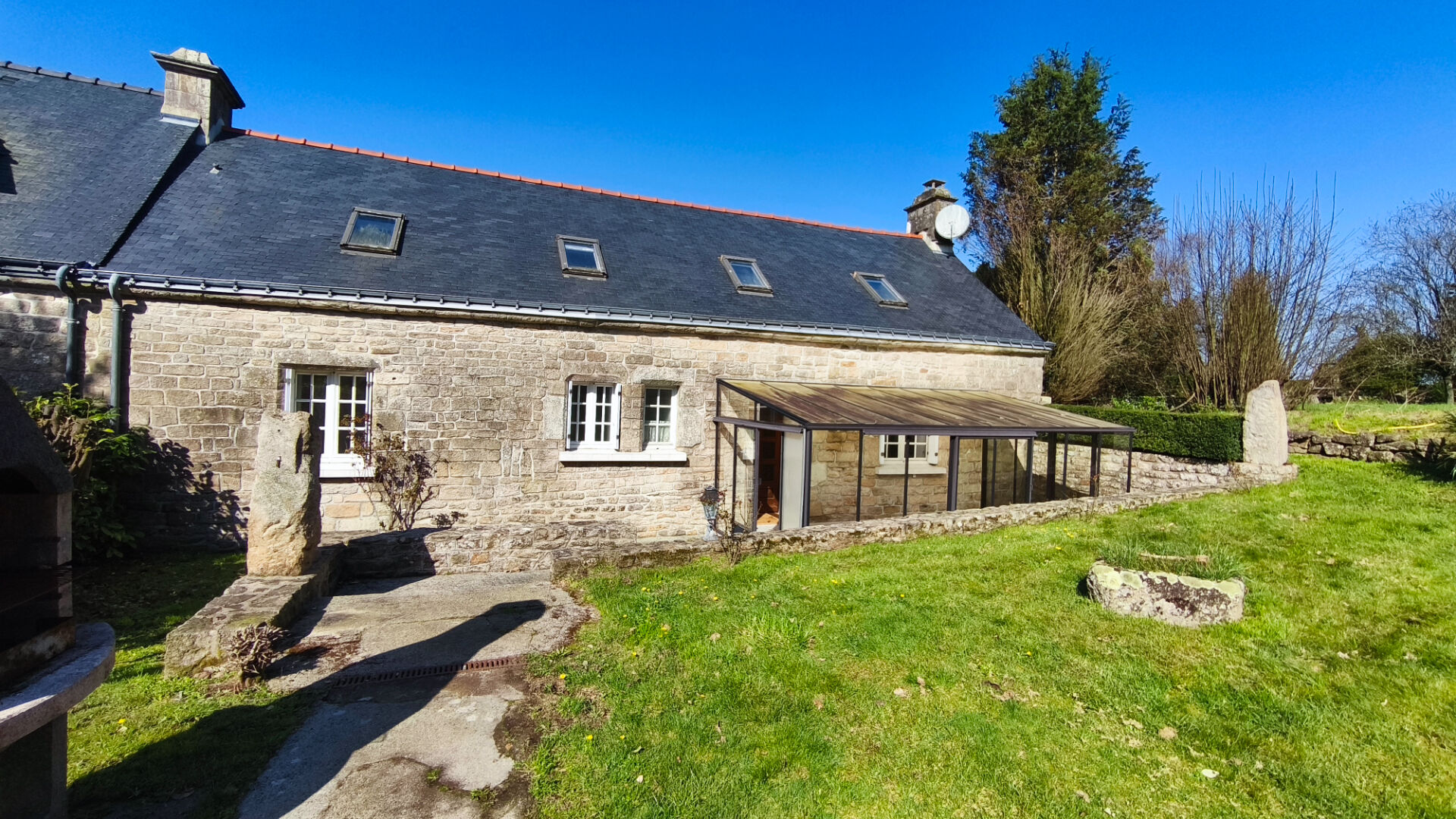 4-bedroom property in Morbihan, Brittany, featuring a stone exterior and a glass conservatory in a green garden.