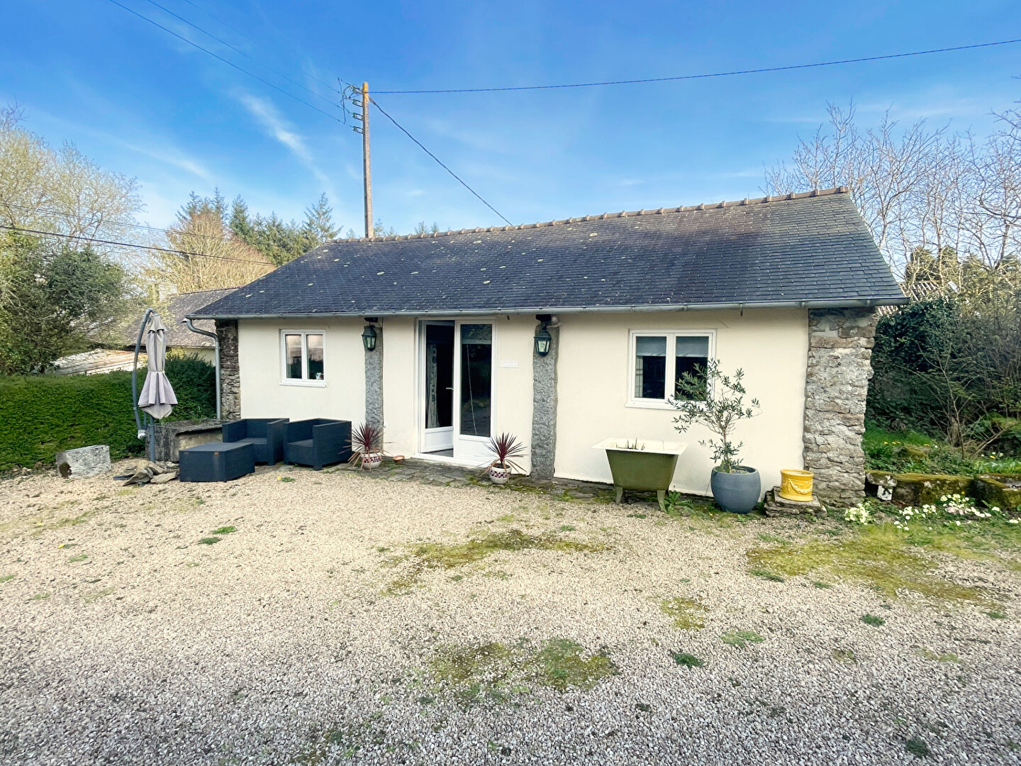 Four-bedroom property in Finistère, Brittany, featuring a gravel drive and garden space, with modern exterior elements.