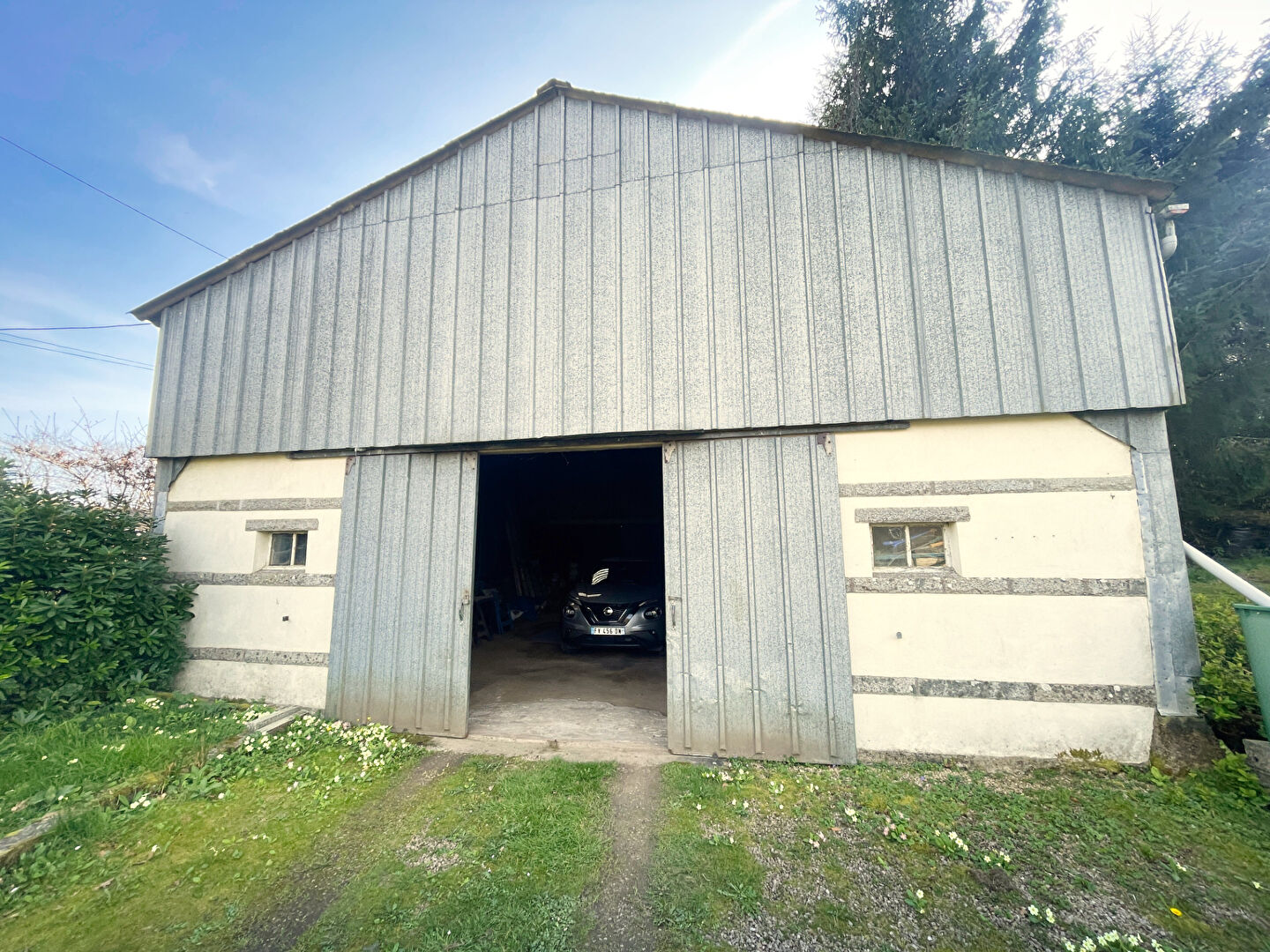Property in Finistère, Brittany, featuring a large barn structure with double doors and ample outdoor space.