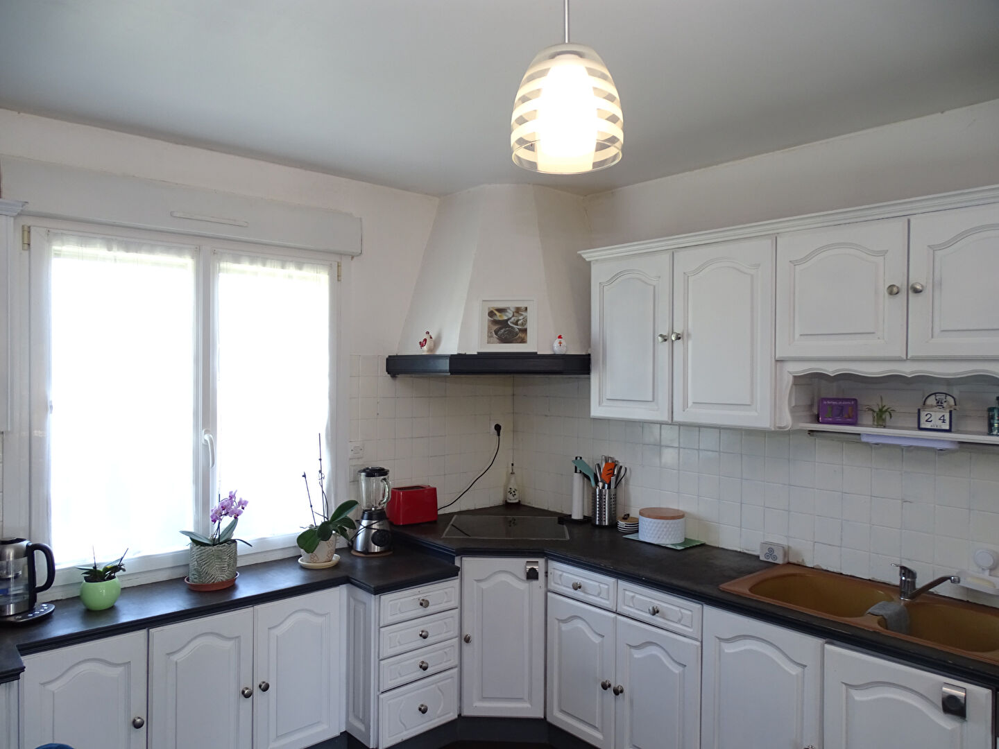 Bright kitchen in a property located in Finistère, Brittany, featuring white cabinetry and modern appliances.