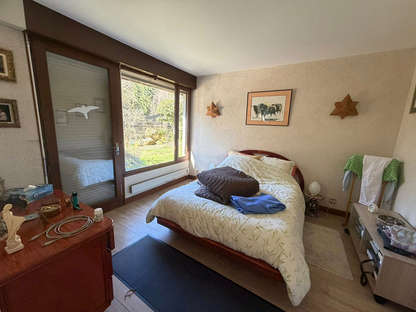 Bright bedroom with garden view, featuring a double bed and wooden furnishings in Haute-Vienne, Nouvelle-Aquitaine.