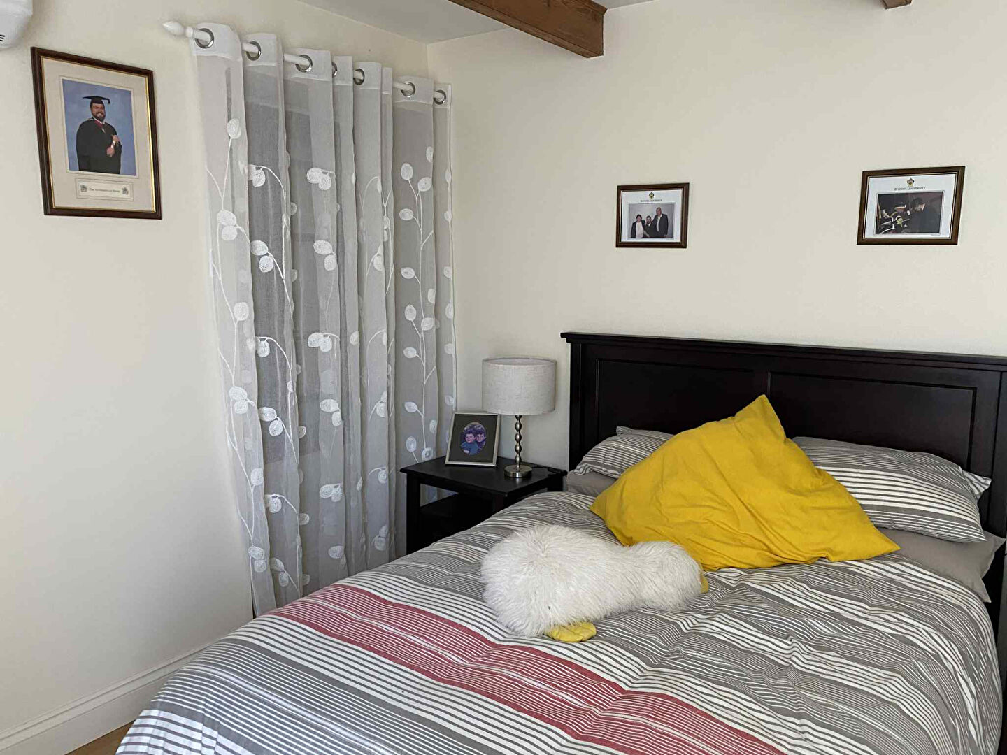 Four-bedroom property in Charente, Nouvelle-Aquitaine, featuring a cosy bedroom with decorative photos and soft furnishings.