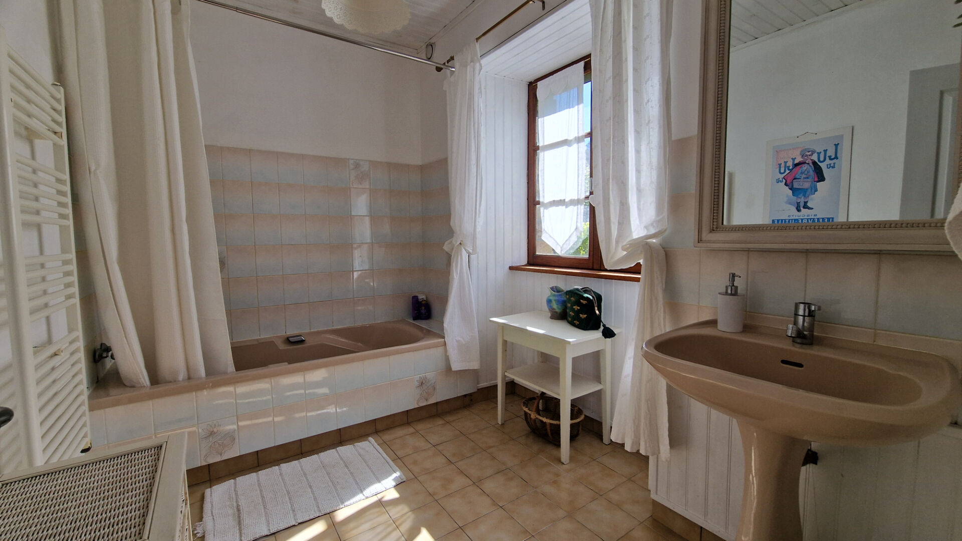 Spacious bedroom featuring a double bed, wooden floors, and natural light in Morbihan, Brittany.