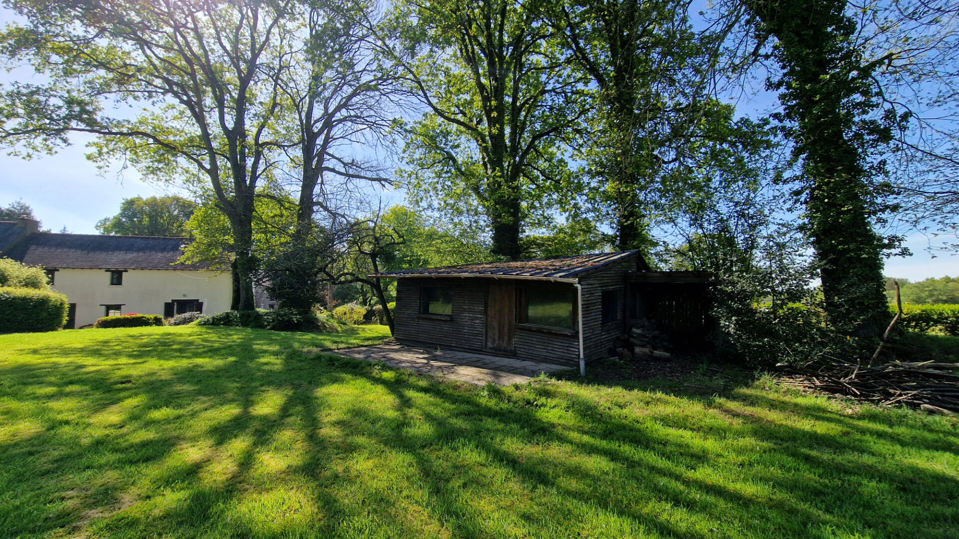 4-bedroom property in Morbihan, Brittany, featuring a garden with mature trees and a charming outbuilding.