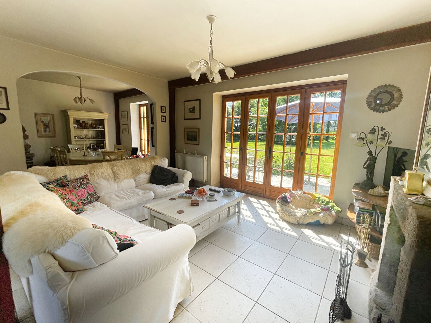 Spacious living area with a cream sofa and fireplace in a property located in Finistère, Brittany.