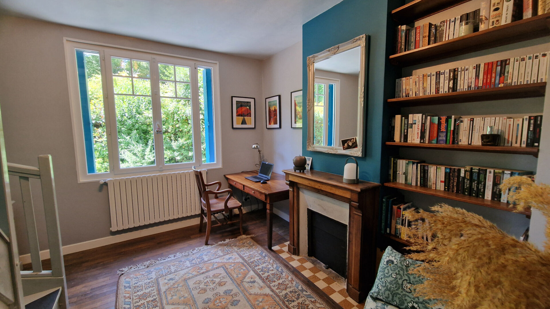 Spacious property in Côtes-d'Armor featuring a study area with bookshelves and large windows overlooking greenery.