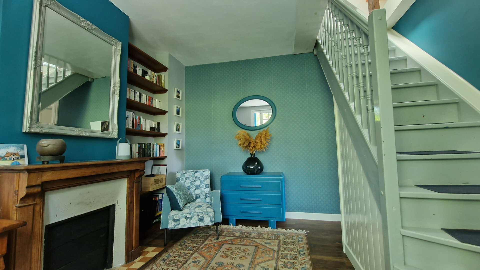 Stylish interior of a property in Côtes-d'Armor, featuring a bright hallway, bookshelves, and decorative elements.