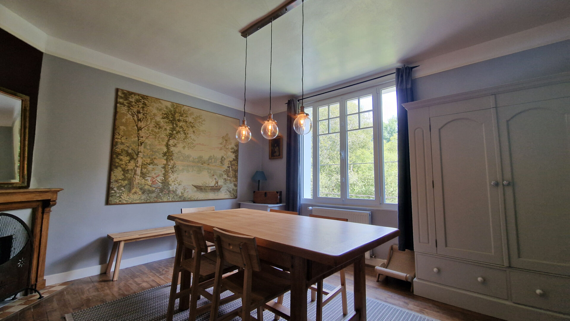 Bright dining area featuring modern lighting, wooden table, and large windows in Côtes-d'Armor, Brittany. Property type