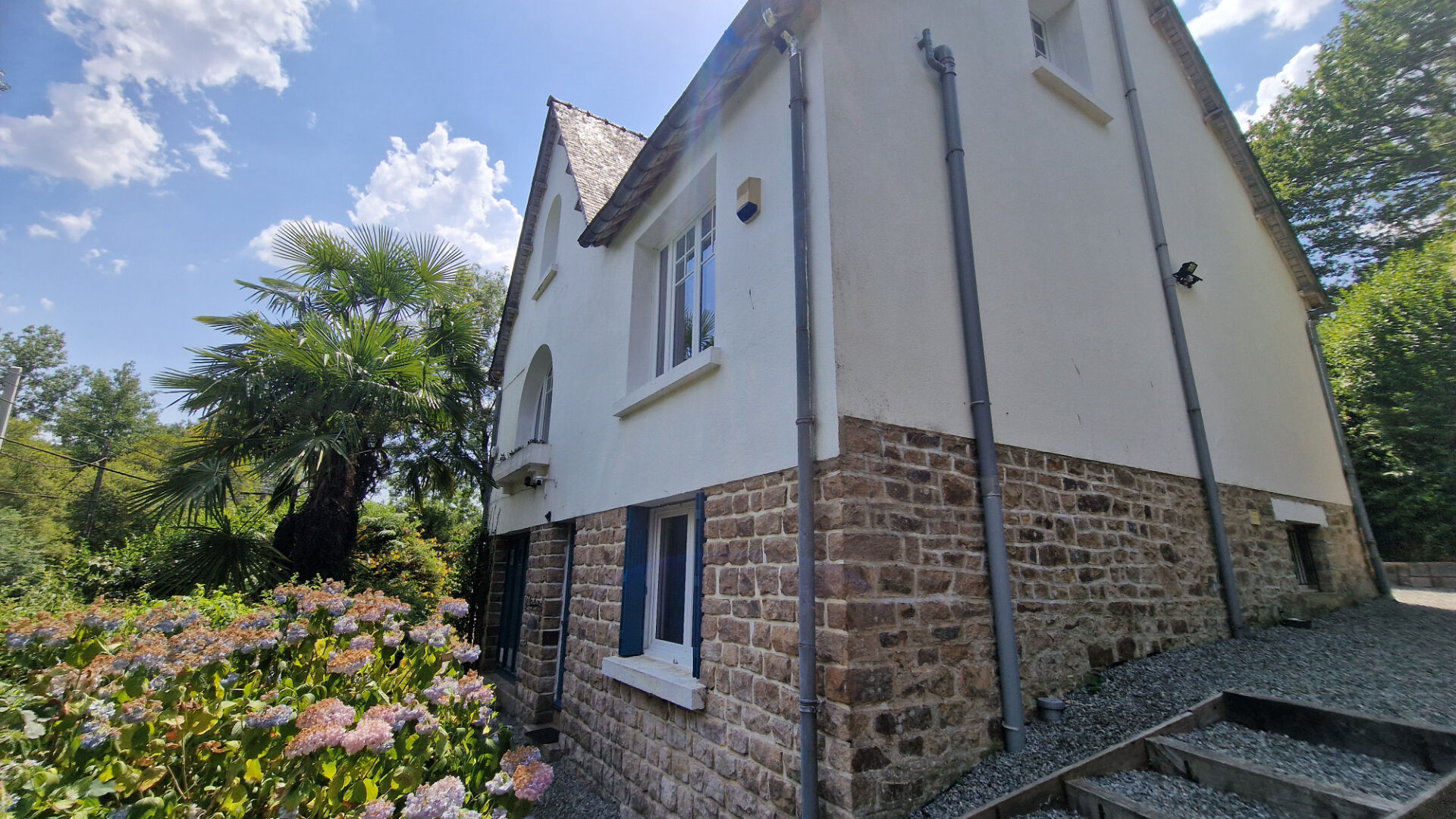 Four-bedroom property in Côtes-d'Armor featuring a stone exterior and lush garden landscaping.