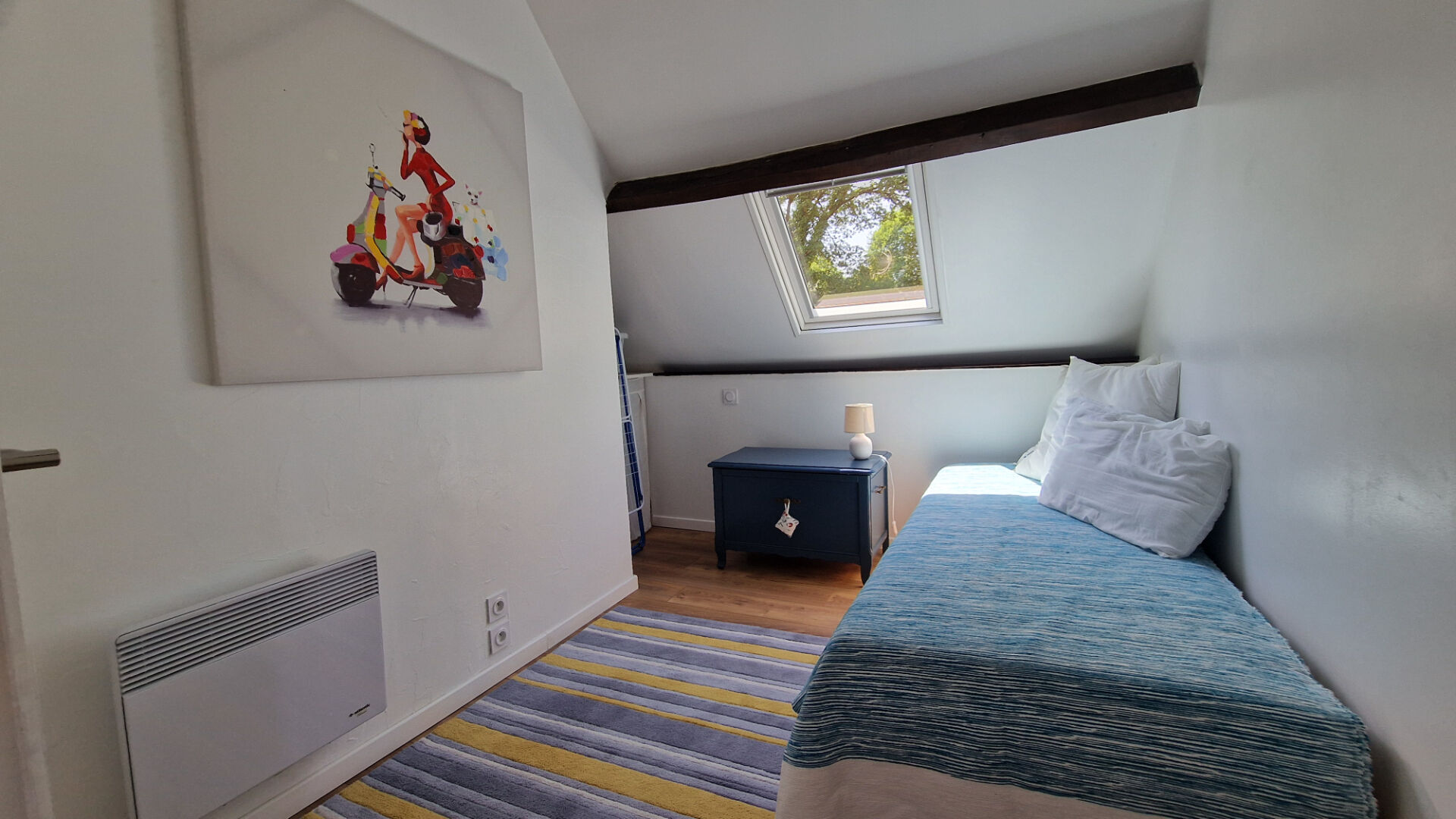 Bright bedroom with sloped ceiling, single bed, and modern decor in Côtes-d'Armor, Brittany. Property type: property.