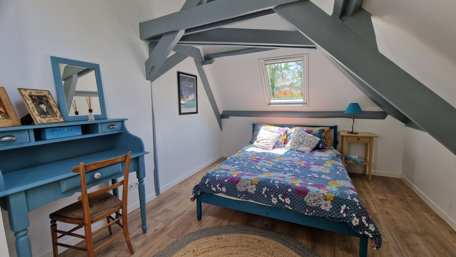 Bright bedroom featuring blue accents and sloped ceiling in a property located in Côtes-d'Armor, Brittany.