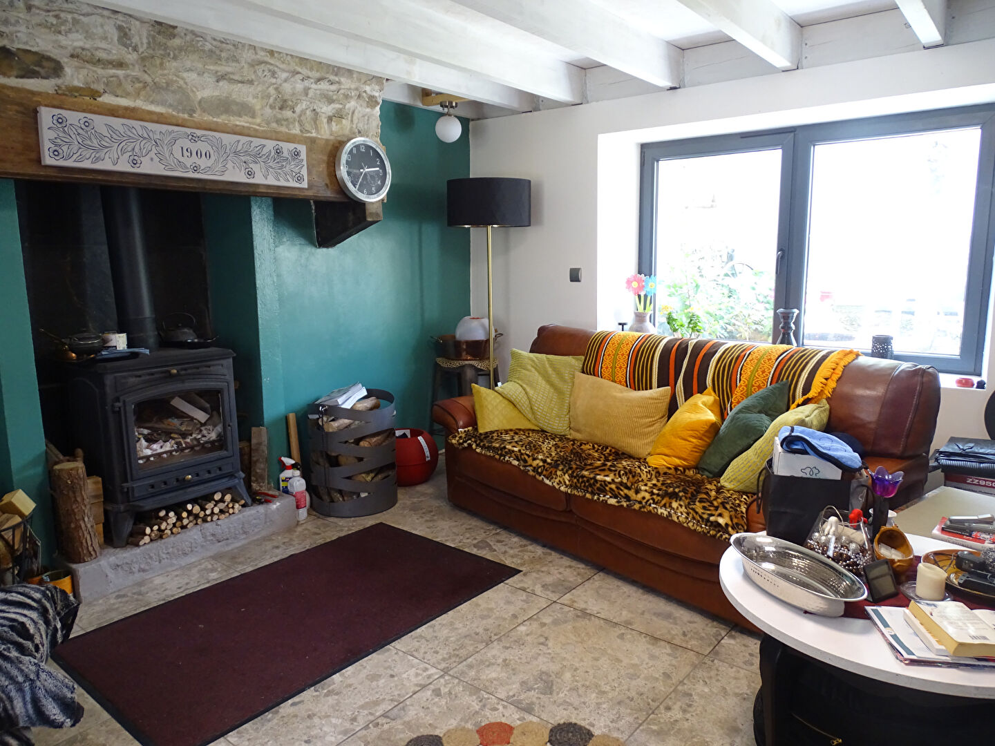 Cosy living area in a property, featuring a wood burner and large windows, located in Finistère, Brittany.