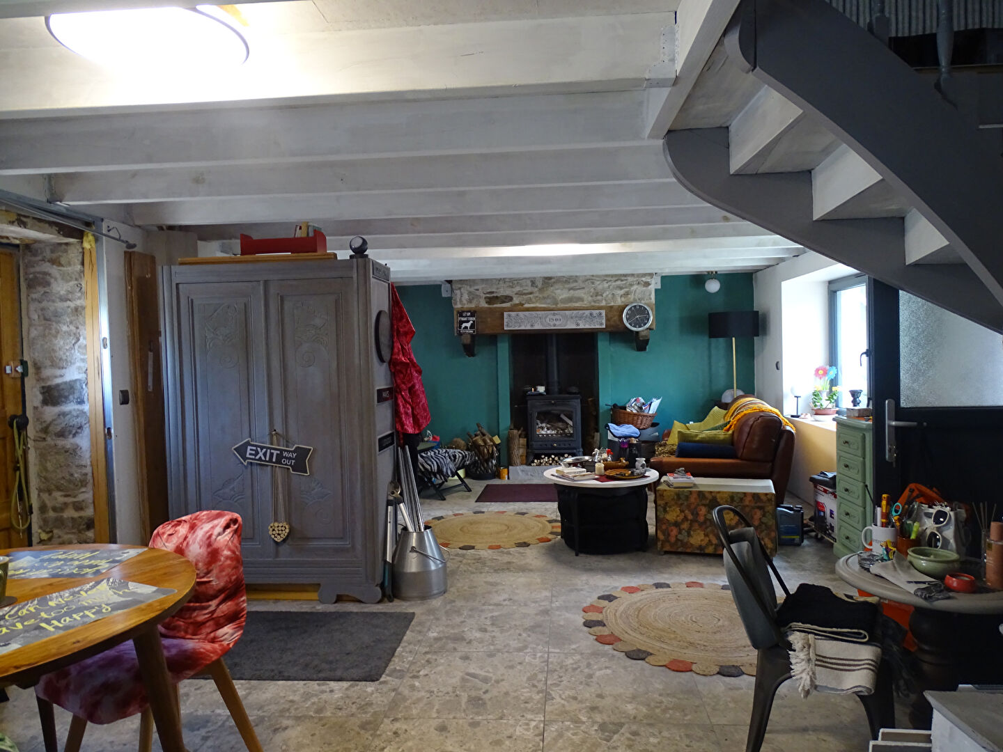 Spacious property in Finistère featuring a cosy living area, stone walls, and a staircase leading to upper levels.