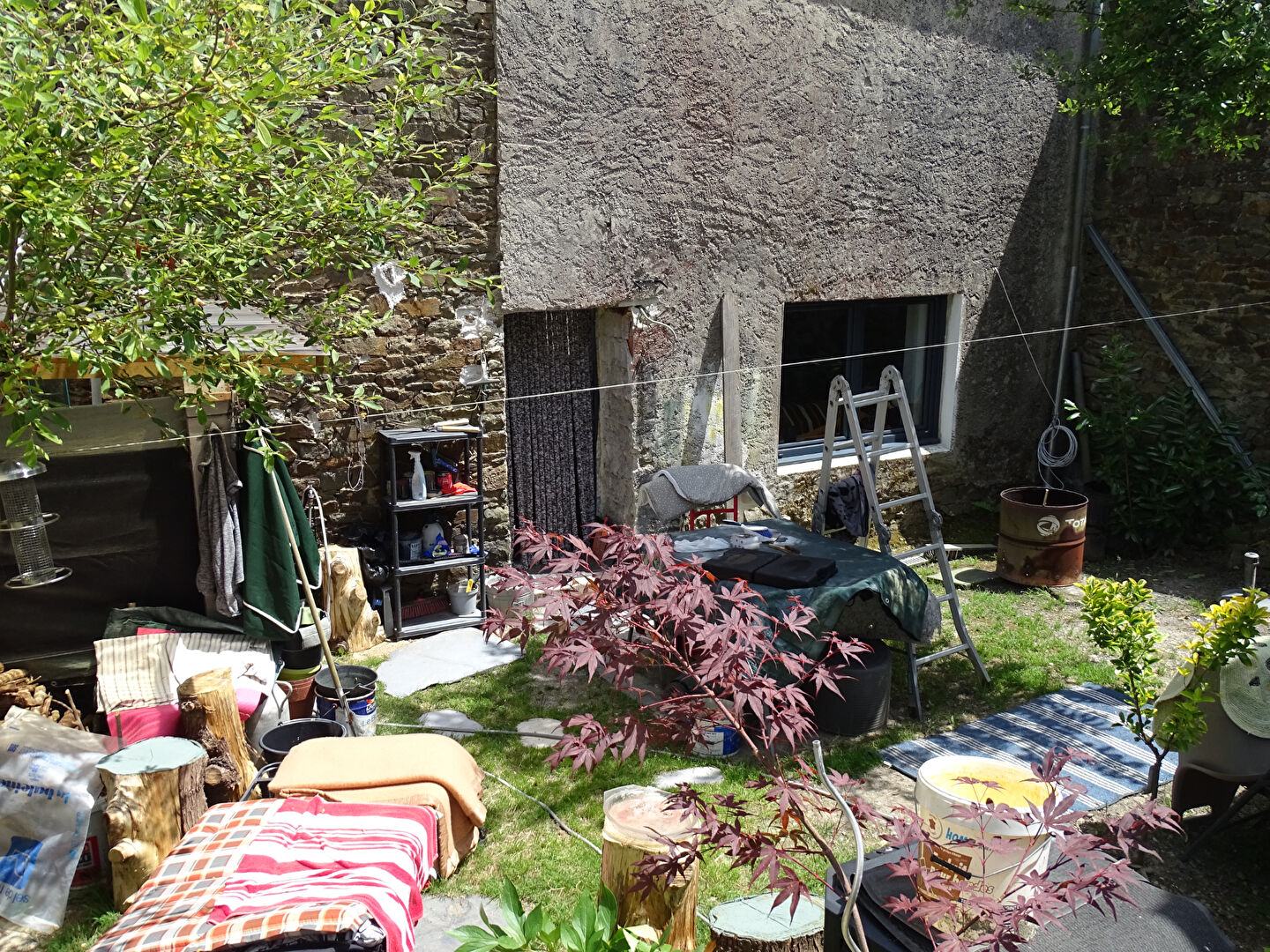 Garden area of a property in Finistère, Brittany, featuring various furnishings and greenery.