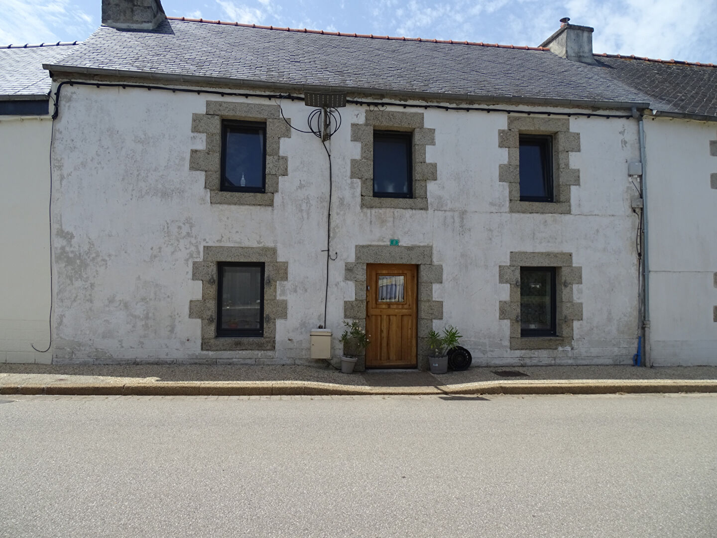 Two-bedroom property in Finistère, Brittany, featuring stone facade and front door with plants on the entrance.